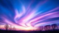 Dramatic purple and blue aurora borealis sky with vibrant streaks of light dancing above silhouetted winter trees at sunset creating magical northern atmosphere.