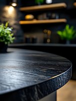 Dark wooden table edge with textured surface in modern kitchen interior, selective focus on black wood grain detail against blurred contemporary decor background.