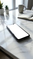 Modern smartphone with blank white screen on marble desk surface with coffee mug and plants in blurred background for app mockup presentations.