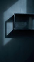 Modern minimalist interior with geometric black frame casting dramatic shadows on textured wall in moody blue lighting for contemporary design projects.