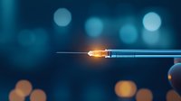 Medical syringe with glowing needle tip against blurred blue bokeh background, illuminated injection concept for healthcare and vaccination.
