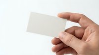 Hand holding blank white business card mockup on clean background for corporate branding and professional identity design templates.