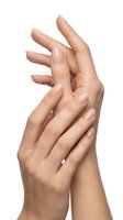 Elegant female hands with natural manicure and nude nail polish isolated on white background for beauty and skincare concepts.