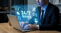 Professional businessman using laptop with glowing 24/7 customer service holographic interface icons in modern office environment for business support.