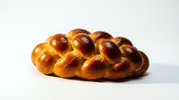 Braided loaf of golden-brown challah bread with glossy egg wash finish, perfect for bakery, food, and culinary content.