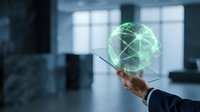 Businessman holding glowing green digital globe with network connections in modern office environment representing global business technology and connectivity.
