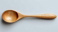 Handcrafted wooden spoon with smooth finish and natural grain pattern, ideal for cooking and serving food in eco-friendly kitchens.