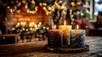 Festive candles on wooden slice with blurred Christmas tree and fireplace in background creating cozy holiday atmosphere.