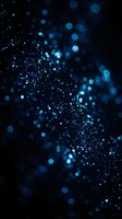 Abstract blue bokeh lights with sparkling particles on dark background creating magical atmosphere for digital design and creative projects.