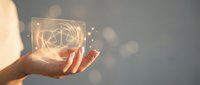 Hands holding glowing geometric sacred geometry symbol with light particles, representing spirituality, technology, and innovation for wellness and digital transformation concepts.