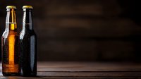 Cold bottles of light and dark craft beer with water drops on dark wooden background, dramatic lighting creates moody atmosphere for beverage photography.