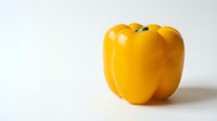 Fresh yellow bell pepper isolated on white background, suitable for food, cooking, nutrition, and recipe design projects.