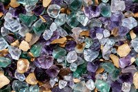 Colorful mineral crystals background with amethyst, fluorite and citrine rough stones. Natural gemstones texture showing raw crystal formations.