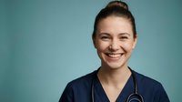 Young female healthcare professional in navy scrubs with stethoscope smiling confidently against turquoise background for medical marketing materials.