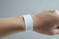 White fabric wristband on human arm against neutral background. Isolated design element suitable for branding, medical applications, event identification, sports merchandise, and promotional material mockups.