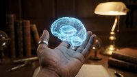 Holographic brain floating above open hands in warm office setting with books and lamp, representing neuroscience, artificial intelligence and mental health concepts.
