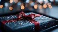 Elegant black gift box with red ribbon and sparkling water droplets against blurred bokeh lights background for holiday celebrations and special occasions.