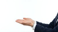 Businessman in dark suit with open palm gesture, presenting or offering concept for corporate communication and business presentations.