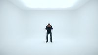 Businessman in dark suit standing alone in empty white minimalist room with clean walls and bright lighting for corporate and professional concepts.