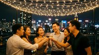 Group of young diverse friends toasting with wine glasses on rooftop terrace with string lights and city skyline at night for celebration party.