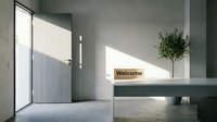 Minimalist modern entryway with welcome mat, gray door, concrete walls, and small olive tree on white shelf in bright natural light.