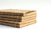 Stack of rustic handmade notebooks with textured natural fiber covers tied with twine, isolated on white background for design use.