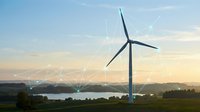 Wind turbine in rural landscape with digital network overlay representing renewable energy and smart grid technology for sustainable power generation.