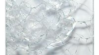 Shattered glass with sharp fragments and cracks scattered across white surface, suitable for backgrounds, textures, and design projects.