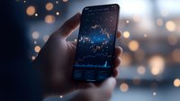 Person holding smartphone displaying financial stock market charts and trading graphs with glowing blue data visualization, suitable for finance, investment, and business applications.