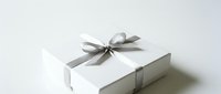 White gift box with elegant silver ribbon bow on clean background for special occasions and celebrations.