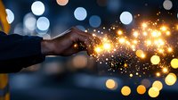 Hand touching magical glowing sparkles and light particles against dark background with bokeh lights, creating mystical energy flow effect.
