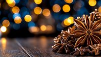 Star anise spice on rustic wooden surface with golden bokeh lights in background creating magical holiday atmosphere for seasonal cooking and decor.