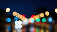 Colorful bokeh lights creating dreamy atmosphere with warm and cool tones against dark background for festive celebrations and urban nightlife.