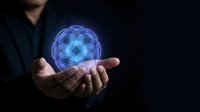 Businessman holding glowing blue holographic mandala symbol in cupped hands against dark background for spiritual technology and digital meditation concepts.