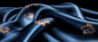 Luxurious navy blue silk fabric with copper metallic floral pattern creates elegant waves and folds on dark background, suitable for fashion and textile design.