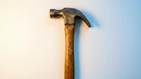 Vintage claw hammer with wooden handle isolated on white background for construction and carpentry projects.