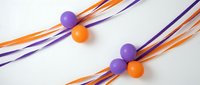 Colorful purple and orange spheres connected by flowing ribbon streams on white background for modern graphic design projects.