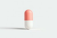 Single pharmaceutical capsule with pink and white colors on light background with soft shadow, isolated medical pill for healthcare concept.