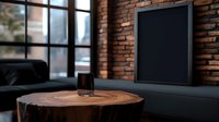 Minimalist living room interior with round wooden coffee table, black frame on exposed brick wall, and dark sofa creating modern industrial atmosphere.