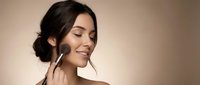 Young woman applying makeup with brush, natural beauty routine, skincare and cosmetics application for daily self-care and wellness lifestyle.