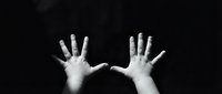 Two open hands reaching upward against dark background expressing hope, surrender, or plea in dramatic black and white photography for emotional concepts.