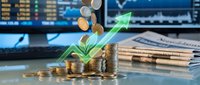 Financial growth concept with stacked coins, green arrow, plant sprout and trading charts on business desk representing investment success and wealth building.