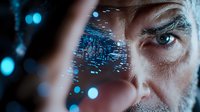 Futuristic digital interface projection on businessman face with glowing blue data visualization and circuit patterns for technology concepts.