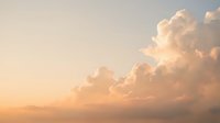Soft pastel clouds drift across golden sunset sky creating dreamy atmospheric background for meditation wellness and peaceful nature concepts.