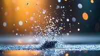 Macro photography of water droplets splashing on reflective surface with orange and blue bokeh background creating magical atmosphere and light effects.