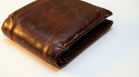 Worn brown leather wallet with aged patina and visible stitching, displayed on white background for commerce and retail use.