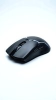 Black wireless gaming mouse with RGB lighting isolated on white background, featuring ergonomic design and textured grip for precision control.