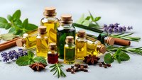 Collection of essential oil bottles with herbs and spices for aromatherapy, natural wellness, spa treatments and holistic healing practices.