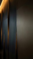 Vertical metal panels with warm golden accent lighting creating dramatic shadows and depth, suitable for modern architectural backgrounds and contemporary design projects.