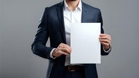 Young Asian businessman in navy blue suit and white shirt holding blank white paper against gray background, professional corporate mockup presentation.
